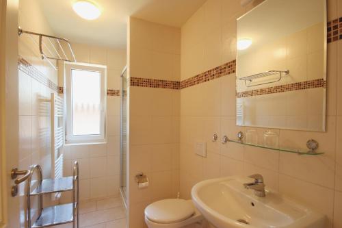 y baño con lavabo, aseo y espejo. en Apartmenthaus Hus Übi by Rujana, en Binz