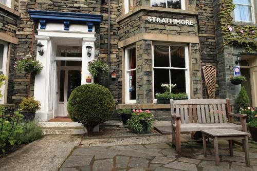a bench in front of a building with a store at Strathmore Guest House in Keswick
