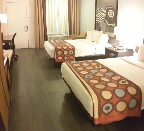 um quarto de hotel com duas camas e uma mesa em Super 8 by Wyndham Florida City/Homestead/Everglades em Florida City