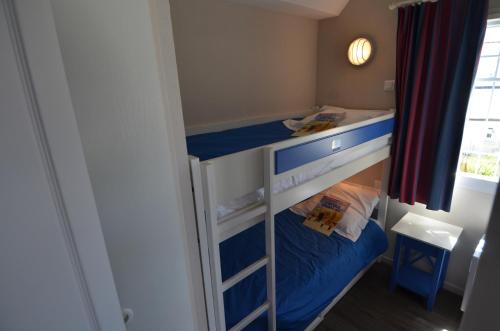 een kleine slaapkamer met een stapelbed bij Residence Cap Marine in Le Guilvinec