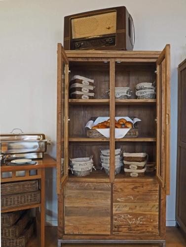 a wooden book shelf with a microwave and dishes at Schloss Spangenberg in Spangenberg