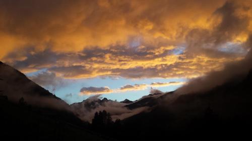 a sunset in the mountains with clouds in the sky at Ferienwohnung Petter in See