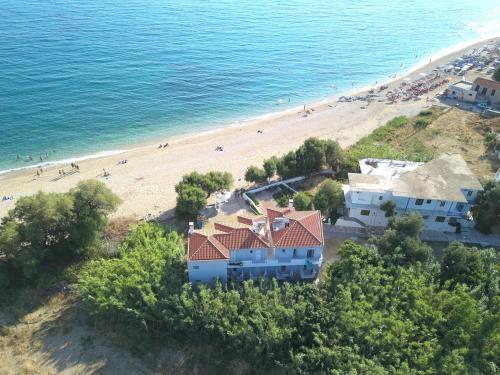 an aerial view of a beach with houses and people at Pano sto Kyma Studios in Plomarion