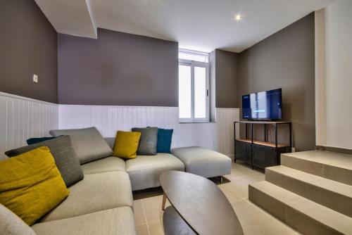 a living room with a couch and a tv at Elegant 4BR Sliema House with Rooftop Jacuzzi in Sliema