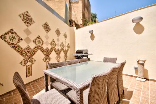 un patio al aire libre con mesa y sillas en Amazing 4-bedroom Sliema Town House with Jacuzzi en Sliema