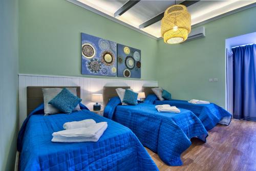 1 dormitorio con 2 camas y edredones azules en Amazing 4-bedroom Sliema Town House with Jacuzzi, en Sliema
