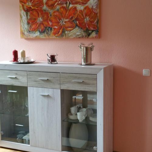 a wooden cabinet in a room with a painting on the wall at ferienhaus-raju-zeltingen in Zeltingen-Rachtig