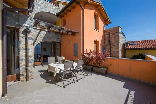 a patio with a table and chairs and a building at Borgo La Sorgente - Erica in Gravedona