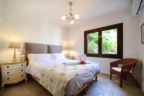 ein Schlafzimmer mit einem Bett, einem Stuhl und einem Fenster in der Unterkunft Las Escaleras - Villa DEKA - 2S in Port d’Andratx