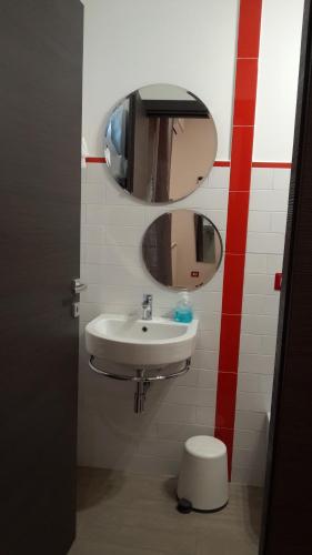 a bathroom with a sink and a mirror and a toilet at EtnaSpecial in Nicolosi