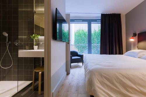 a hotel room with a bed and a bathroom with a shower at T2 bis luxe hyper centre piscine in Bordeaux