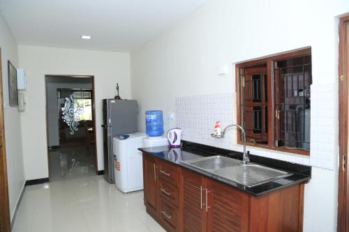 a kitchen with a sink and a refrigerator at Superior rest in Jaffna