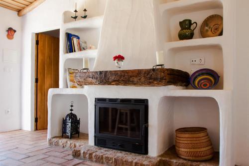 a fireplace in a living room with white walls at Monte Varandas in Arronches