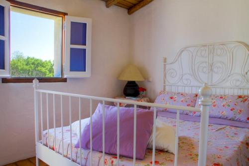 a bedroom with a white bed and a window at Monte Varandas in Arronches