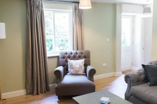 a living room with a chair and a window at Saltmarshe Hall in Saltmarshe