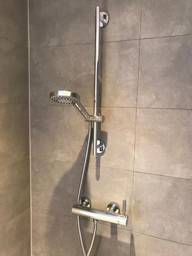 a shower with a shower head in a bathroom at Villa Anna with sauna in Winterswijk in Winterswijk
