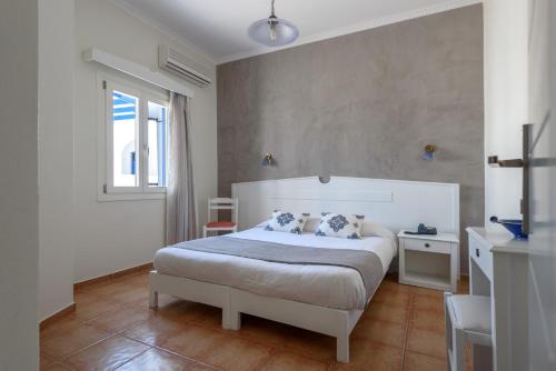 a bedroom with a white bed with two pillows at Anemomilos in Oia