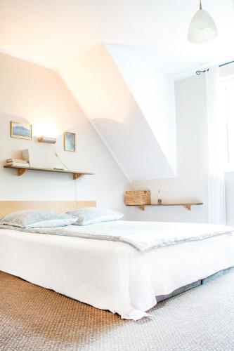 a white bed in a room with a staircase at Motel Hotelik in Olsztyn
