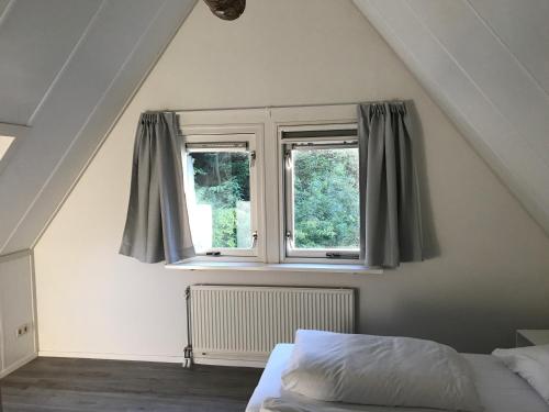 un dormitorio con una cama y una ventana en Villa Anna with sauna in Winterswijk, en Winterswijk