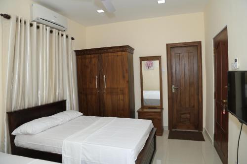 a bedroom with a bed and a flat screen tv at Superior rest in Jaffna