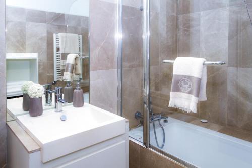 een badkamer met een douche, een wastafel en een bad bij Liiiving in Porto | Ribeira Boutique Apartment in Porto