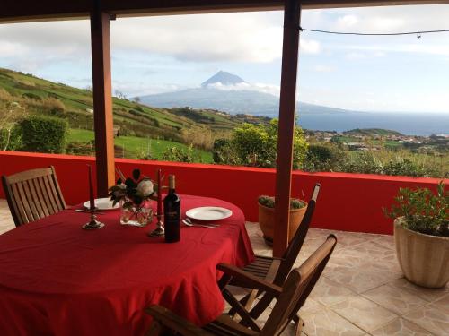 a red table with a view of a mountain at Casa Farrobo in Horta