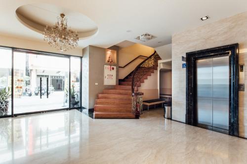 eine Lobby mit einer Treppe und einem Kronleuchter in der Unterkunft Hotel South Sea in Kaohsiung