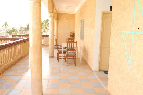 a porch with chairs and a table on a balcony at Hotel Safari COTONOU in Cotonou