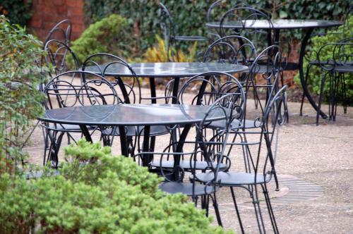 a group of tables and chairs in a garden at Marston Farm Hotel in Sutton Coldfield