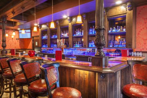 a bar with a wooden counter and bar stools at Grand Canyon Plaza Hotel-South Rim in Tusayan