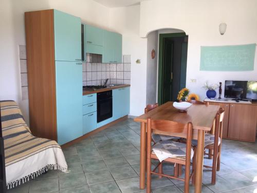 cocina con mesa de madera y nevera azul en Villino vicino al mare, en Budoni