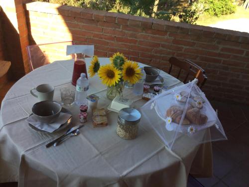 a white table with sunflowers and a vase of flowers at Villa Niccoli in Castelfiorentino