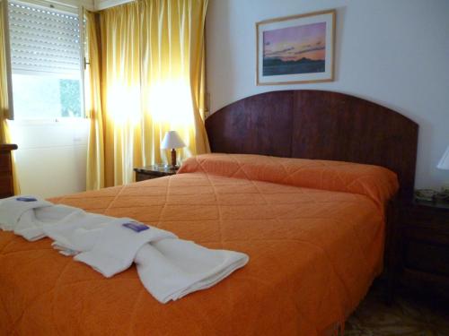 een slaapkamer met een bed met een oranje sprei bij Belvedere Hotel para Adultos in Santa Rosa de Calamuchita