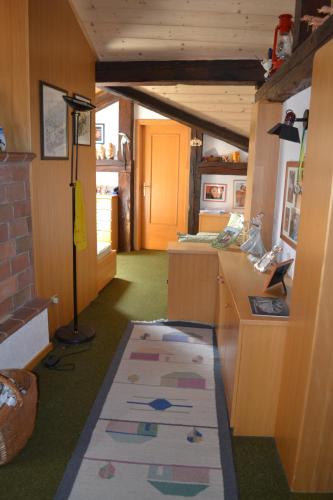 a room with a kitchen with a rug on the floor at B&B La Tana dell'Orso - Die Bärenhöhle in Castello di Fiemme