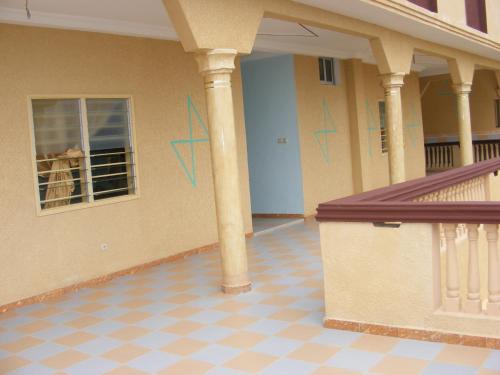 a porch with columns and a window on a house at Hotel Safari COTONOU in Cotonou