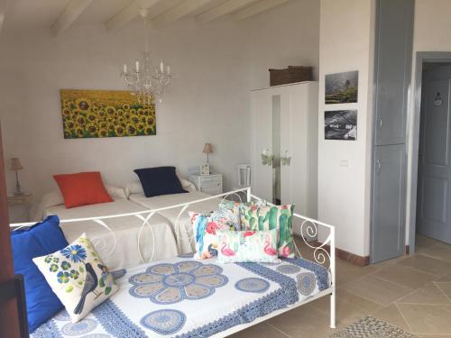 a bedroom with a white bed with colorful pillows at El Laurel in Frontera
