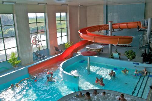 a large indoor swimming pool with a water slide at Hotel Kolna in Krakow