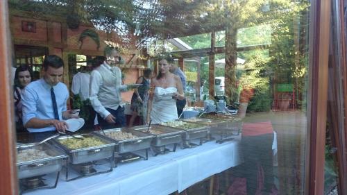 a group of people standing around a buffet of food at Schneiderlein Hotel in Limbach - Oberfrohna