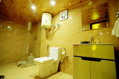 a bathroom with a toilet and a sink at Amara Resorts Manali in Manāli
