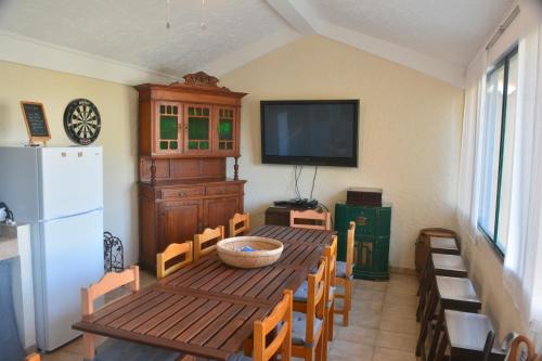 a dining room with a table and a white refrigerator at The Fig Boutique Suites in Salir de Porto