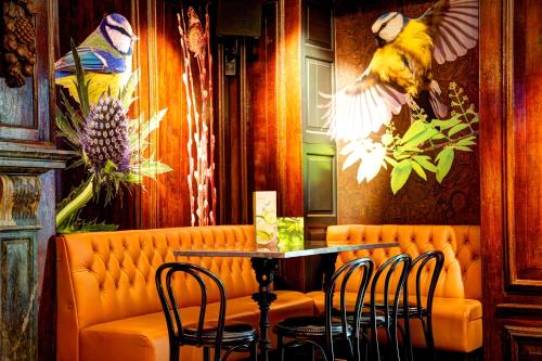 a restaurant with an orange couch and a table at Oddfellows Chester Hotel & Apartments in Chester