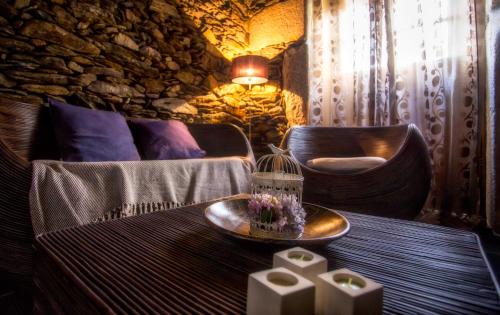 a room with a table with a bird cage and chairs at Casas Peralta - Leira Pereira in Cabreiros
