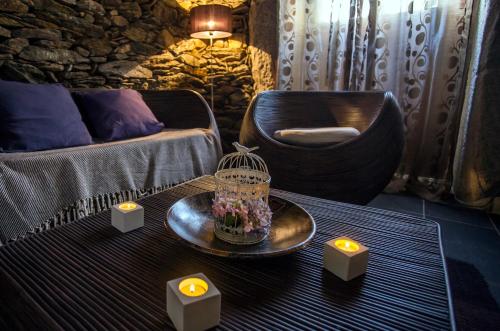 a living room with a chair and a table with candles at Casas Peralta - Leira Pereira in Cabreiros
