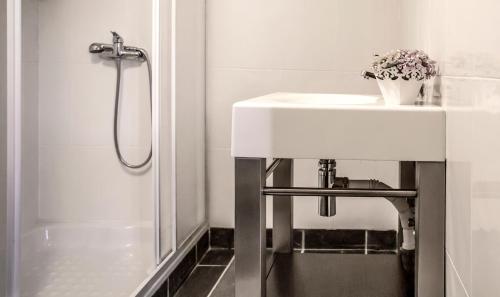 une salle de bain blanche avec un lavabo et une douche dans l'établissement Casas Peralta - Leira Pereira, à Cabreiros