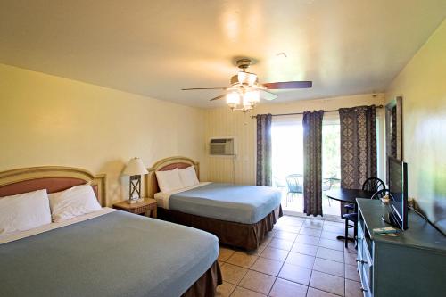 a hotel room with two beds and a television at Ocean Villa Inn in San Diego