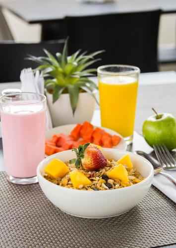 un tazón de comida con fruta y un tazón de leche en Hotel Madeiro, en Medellín