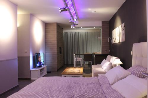 a bedroom with a bed and a living room at B&B Au Roman Païs in Braine-le-Château