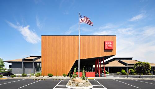 a building with an american flag in a parking lot at Red Lion Hotel Wenatchee City Center in Wenatchee