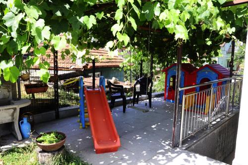 a playground with a red slide at Family apartment with garden in Sarajevo