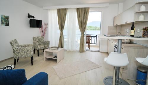 ein Wohnzimmer mit Tisch und Stühlen und eine Küche in der Unterkunft Apartments Zukovac in Tivat